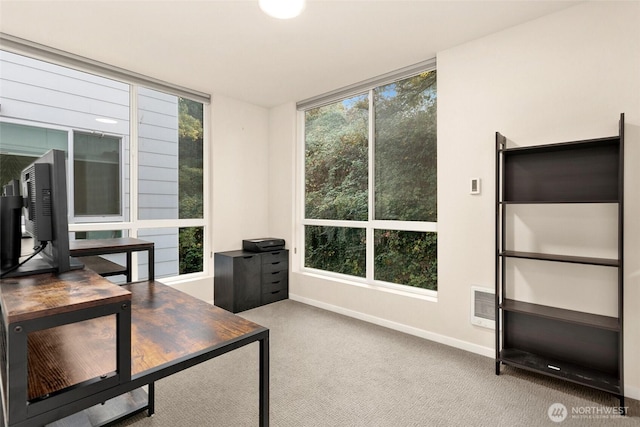 office space featuring a healthy amount of sunlight, visible vents, and light colored carpet