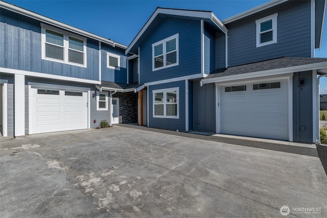 view of front of house with driveway, a shingled roof, and an attached garage