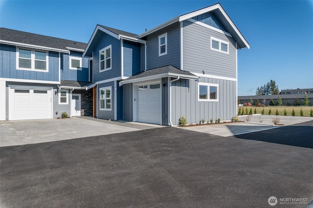 view of front of house featuring board and batten siding, an attached garage, and aphalt driveway