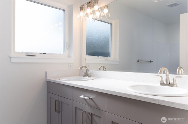 bathroom featuring double vanity, a sink, and visible vents