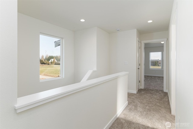 corridor featuring an upstairs landing, recessed lighting, baseboards, and light colored carpet