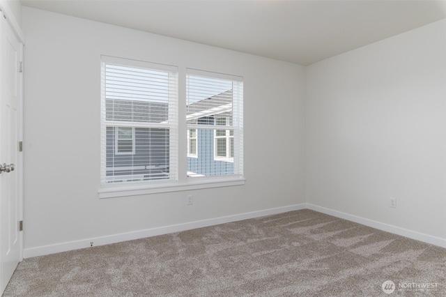 unfurnished room featuring light colored carpet and baseboards