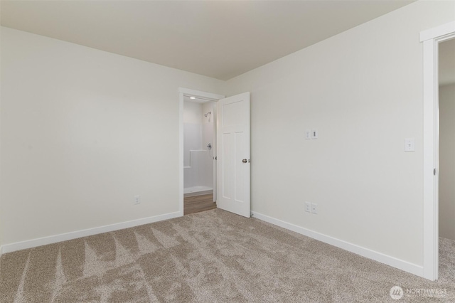 carpeted empty room featuring baseboards