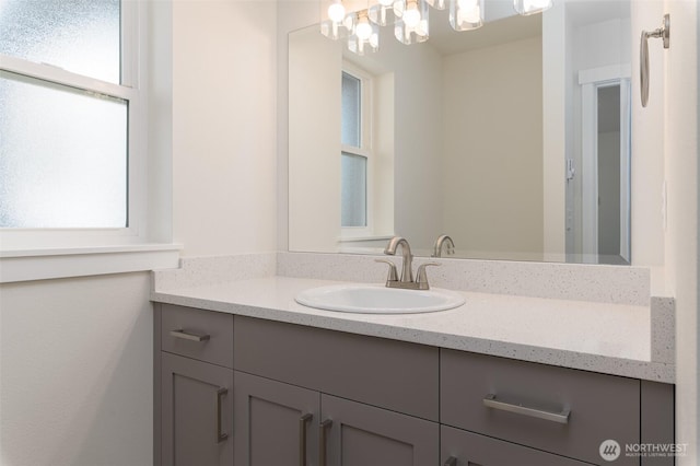 bathroom with an inviting chandelier and vanity