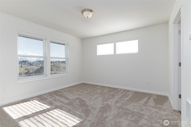 empty room featuring baseboards and carpet flooring