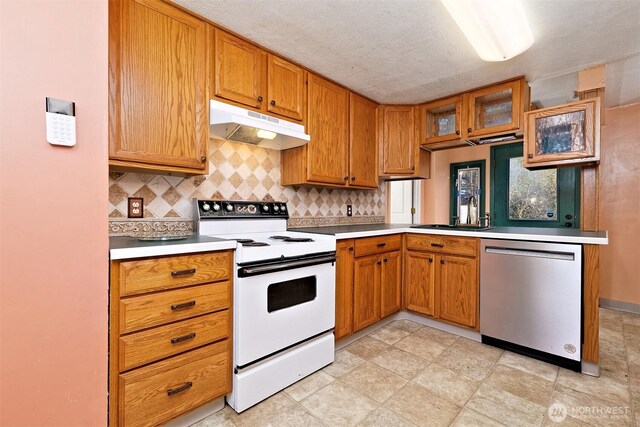 kitchen with under cabinet range hood, a sink, light countertops, dishwasher, and white range with electric cooktop