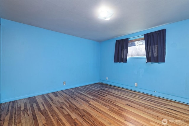 unfurnished room featuring wood finished floors and baseboards