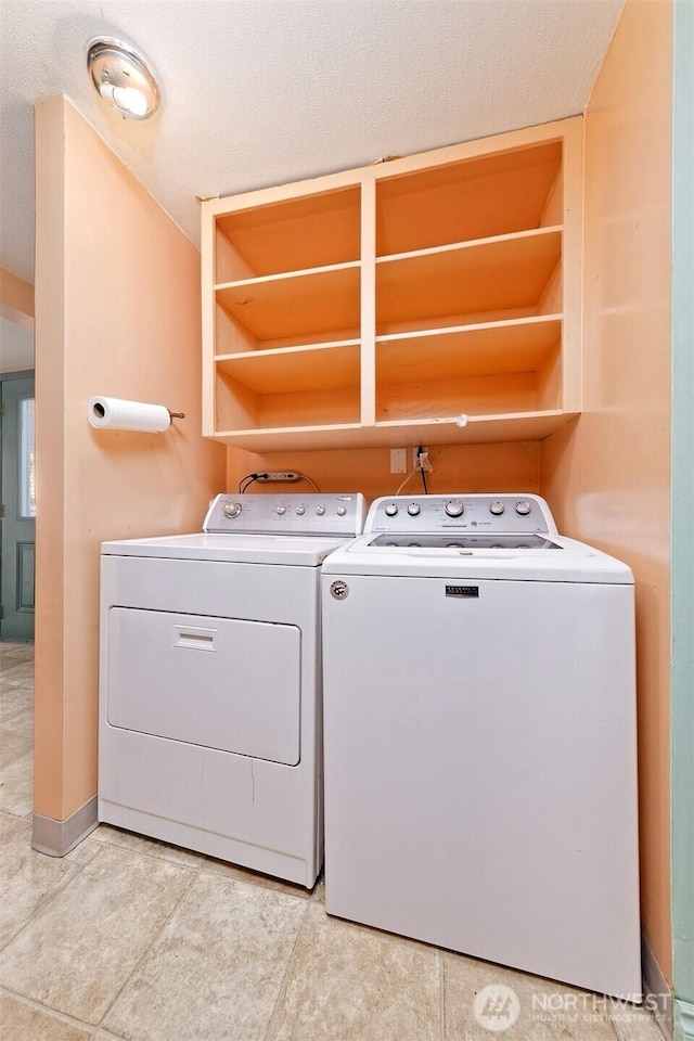 laundry area featuring laundry area, washing machine and clothes dryer, and light tile patterned floors