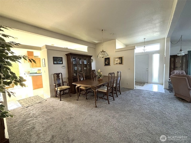 carpeted dining room featuring a textured ceiling