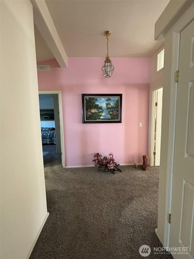 hall with visible vents, baseboards, and carpet