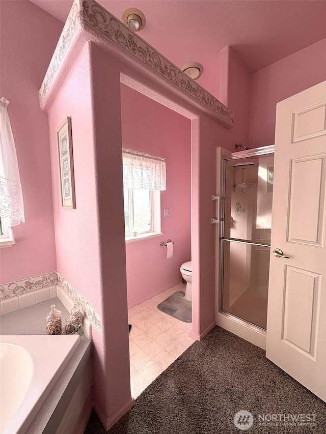 bathroom with tile patterned floors, toilet, and a stall shower