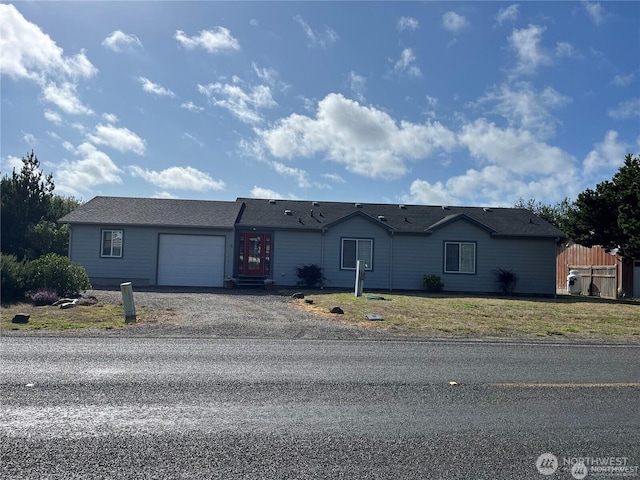 single story home with driveway, a front yard, and an attached garage