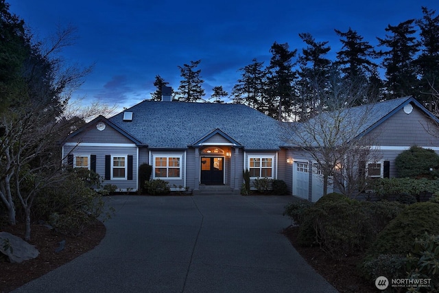 view of front of property with driveway, an attached garage, and roof with shingles