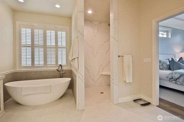 full bath featuring a wealth of natural light, a marble finish shower, a freestanding tub, and connected bathroom
