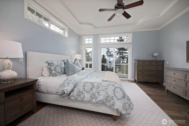 bedroom featuring dark wood-type flooring, ornamental molding, ceiling fan, and a raised ceiling