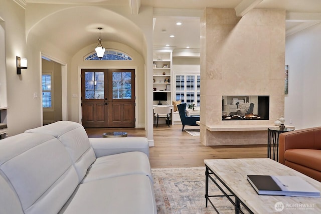 living room with a multi sided fireplace, wood finished floors, french doors, and recessed lighting