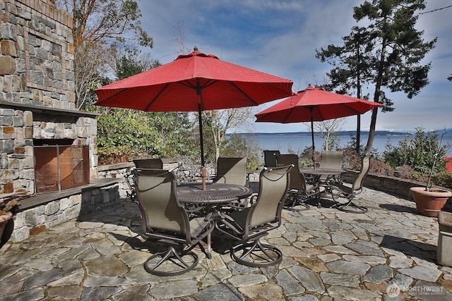 view of patio / terrace featuring outdoor dining area and an outdoor stone fireplace