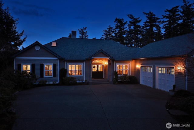 view of front facade featuring driveway, an attached garage, a chimney, and roof with shingles