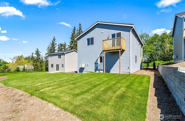 rear view of property featuring fence, a lawn, and a balcony