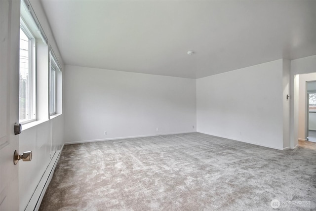 carpeted empty room with a baseboard radiator