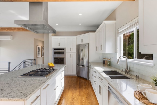 kitchen with island range hood, stainless steel appliances, a sink, white cabinetry, and a wall mounted air conditioner