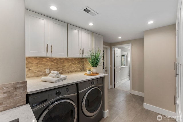 laundry area with laundry area, washing machine and dryer, visible vents, and recessed lighting