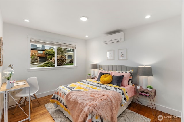 bedroom with light wood-style floors, recessed lighting, baseboards, and a wall mounted air conditioner