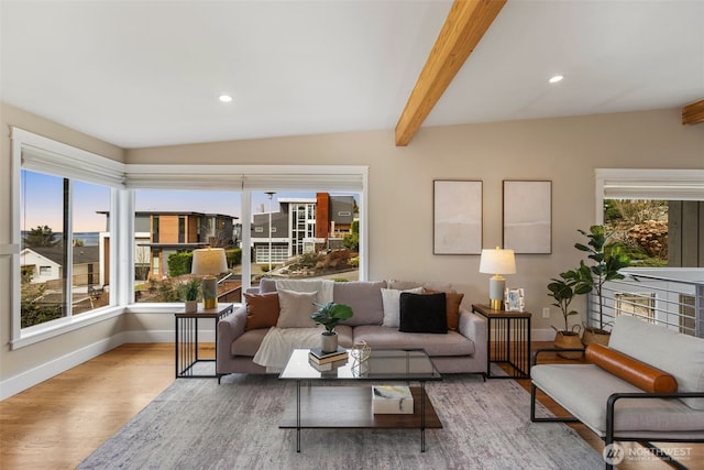 living room with plenty of natural light, beamed ceiling, baseboards, and wood finished floors