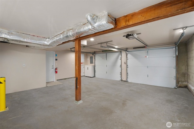 garage with a garage door opener, washer / dryer, and electric panel