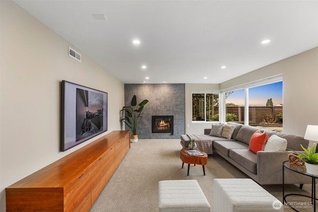 living room featuring a fireplace, carpet flooring, visible vents, and recessed lighting