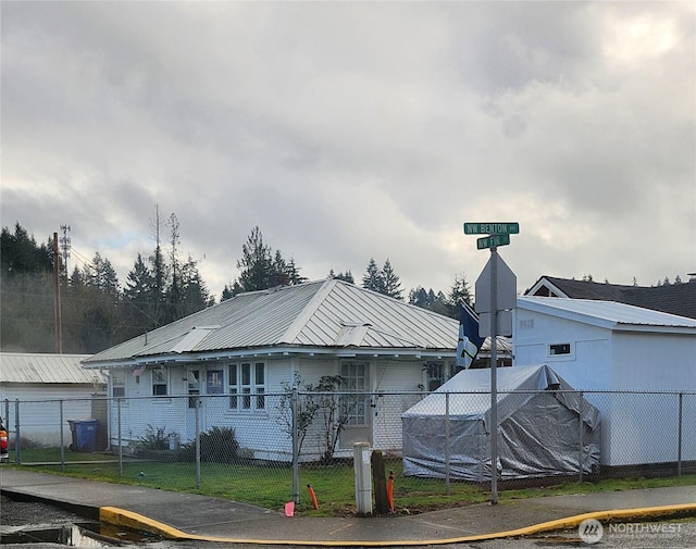 view of property exterior featuring metal roof and fence