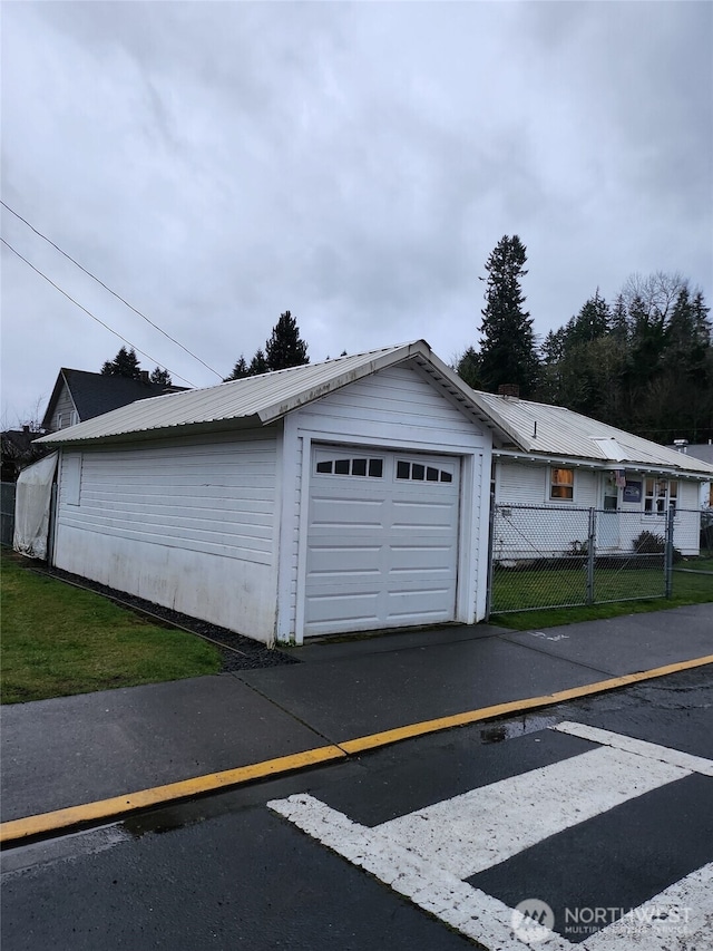 garage with fence and driveway