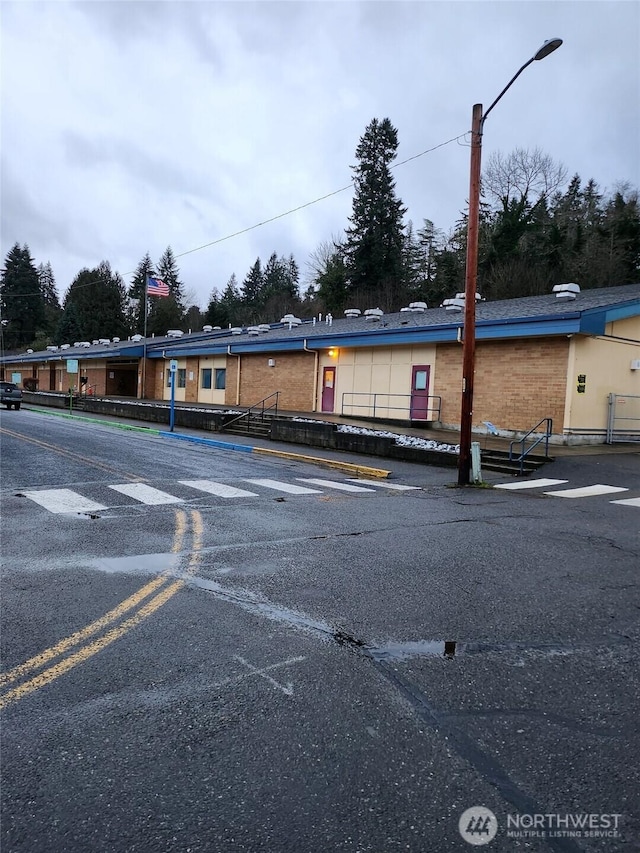 exterior space with uncovered parking and brick siding