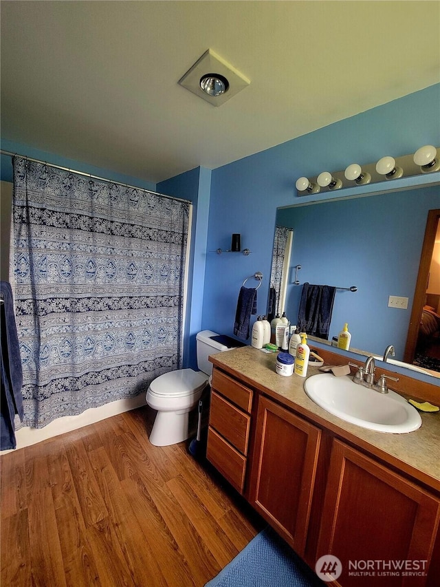 full bathroom featuring toilet, wood finished floors, and vanity