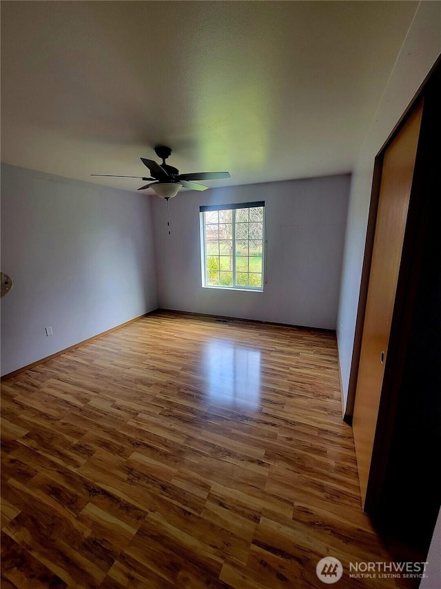 unfurnished room with wood finished floors and a ceiling fan