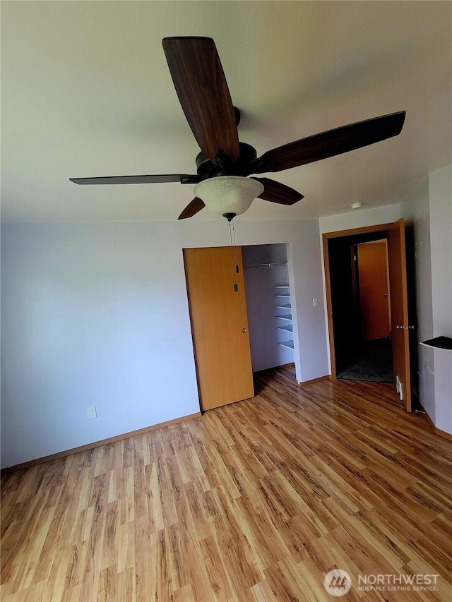 unfurnished bedroom with wood finished floors, a ceiling fan, and baseboards