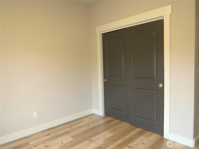 empty room with light wood-style flooring and baseboards