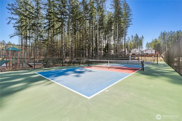 view of tennis court featuring fence