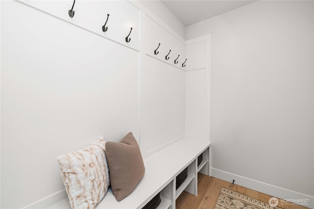 mudroom featuring light wood finished floors and baseboards