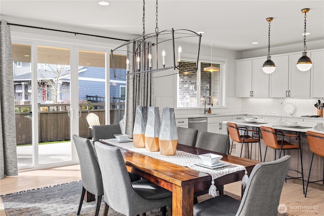 dining room featuring recessed lighting, light wood finished floors, and an inviting chandelier