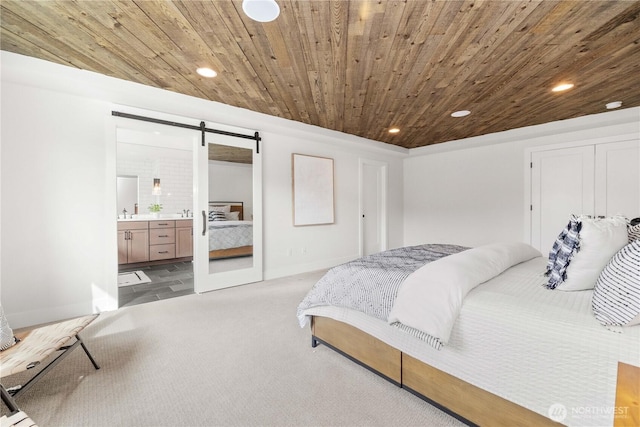 bedroom featuring a barn door, light colored carpet, wooden ceiling, ensuite bathroom, and recessed lighting