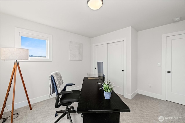 home office featuring light carpet and baseboards