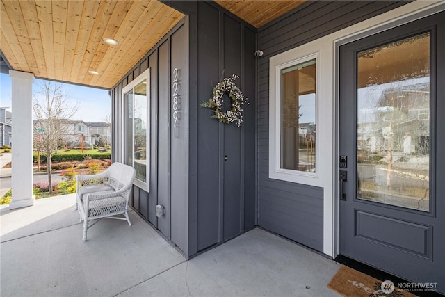 property entrance featuring covered porch and board and batten siding