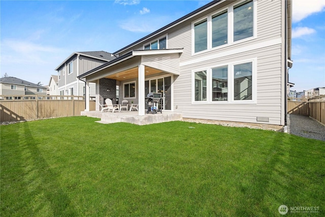 rear view of property with a yard, a fenced backyard, and a patio