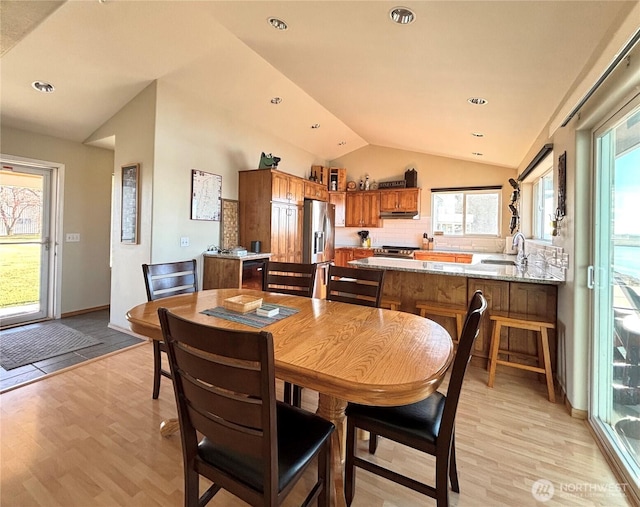 dining room with lofted ceiling, light wood finished floors, and recessed lighting