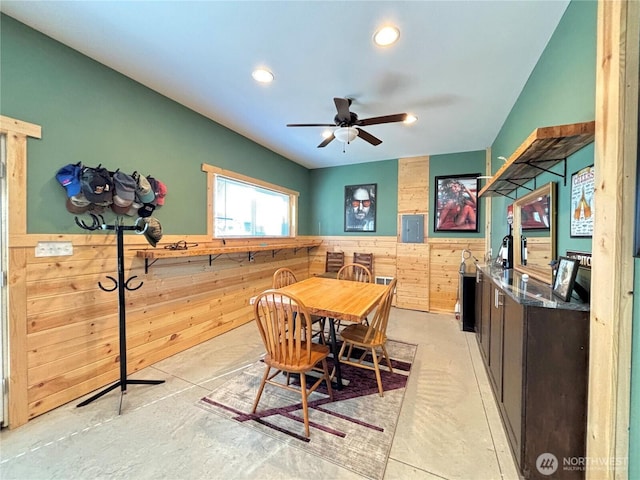 dining room featuring a wainscoted wall, indoor wet bar, recessed lighting, a ceiling fan, and wood walls