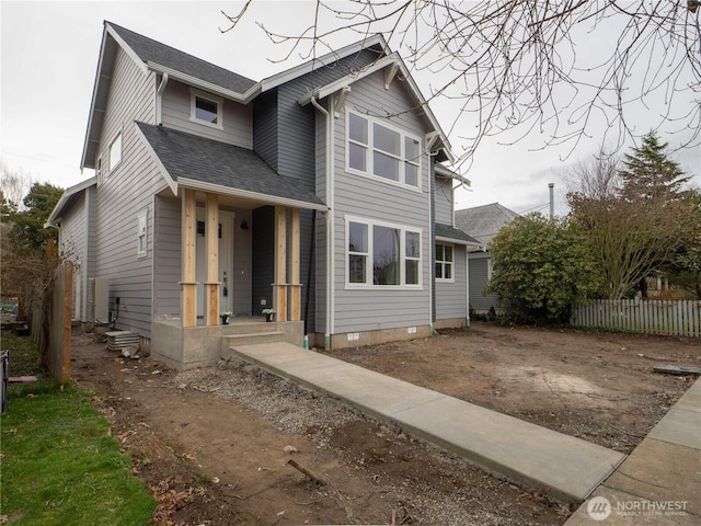 view of front of home featuring a shingled roof and fence