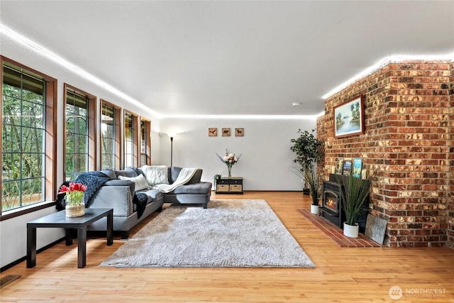 living room featuring light wood-style floors, a wood stove, and visible vents