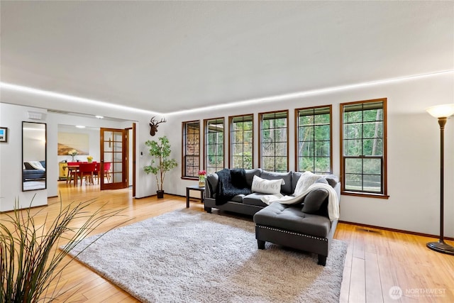 living area with baseboards, visible vents, and light wood finished floors