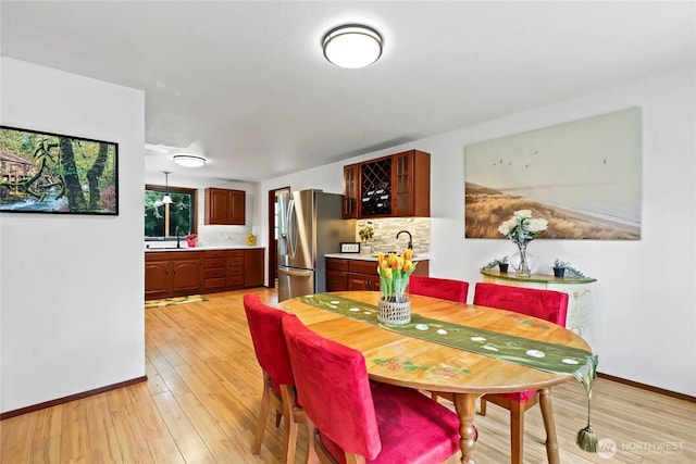 dining room with baseboards and light wood finished floors